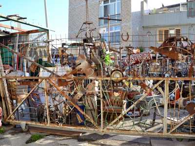 ...il cui figlio Simone, nell�attigua via Massaua crea sculture con pezzi riciclati in un surreale cortile straripante di oggetti tra i pi� disparati