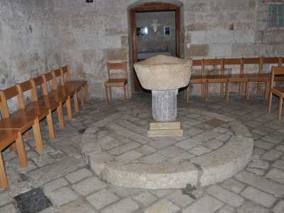 In un angolo ecco il fonte battesimale in pietra