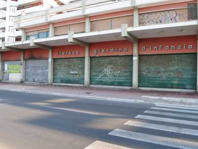 La scritta bianca �Il bruco giardino d�infanzia� testimonia qui la passata presenza di un nido. Accanto le serrande abbassate del ristorante Onda Blu, distrutto da un incendio doloso nel novembre del 2007