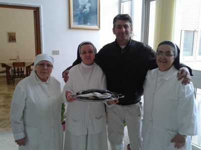 Massimiliano Iamundo con le suore dell'orfanotrofio mentre dona il pescato del raduno