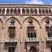 La facciata esterna di palazzo Fizzarotti divisa in cinque campate, con arcate ogivali e medaglioni nelle intersecazioni e chiusa da due torrette