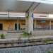 L'interno spettrale della stazione tra vegetazione spontanea, scritte sui muri e il cartello che indica la fermata "Sannicandro di Bari" ancora presente