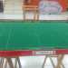 Un campo da gioco di Subbuteo con mini cartelli pubblicitari, recinzioni e alcuni tifosi