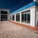 ...conduce all'edificio, che si staglia con le sue caratteristiche ed ampie vetrate