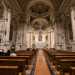 Non ci resta ora che varcare il massiccio portone in legno della chiesa: posto il primo passo su un lucido marmo marroncino a contorni neri si apre davanti a noi un ricco scenario