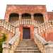 Una doppia e nobile scalinata delimitata da una serie di colonnine bianche conduce al piano nobile introdotto da un patio ad archi