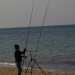 Un pescatore impegnato a montare una canna da pesca