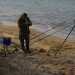 Un pescatore impegnato a montare le sue canne da pesca