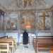 Una fedele in preghiera davanti all'affresco dell'Annunciazione, all'interno della chiesetta dell'Annunziata