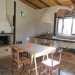 La cucina e sala da pranzo della casa in paglia. Sullo sfondo si nota la cappa artigianale, la cui struttura interna  fatta di rami di ulivo intrecciati e ricoperti di terra e calce