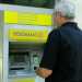 Il signor Pasquale Aiuola mentre aspetta che torni la corrente elettrica davanti al postamat dell'ufficio postale di Santo Spirito, per poter avere le banconote richieste e rimaste bloccate dalla sospensione di energia elettrica