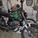 Accanto si trova una Aermacchi Harley Davidson verde e nera del 1974 