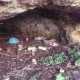 Interno di una grotta a cala Colombo, piena di rifiuti
